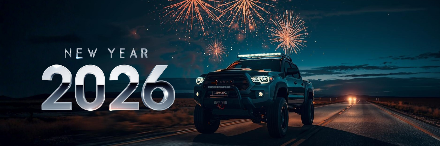 Truck on a road with fireworks and 'New Year 2026' text in the night sky.